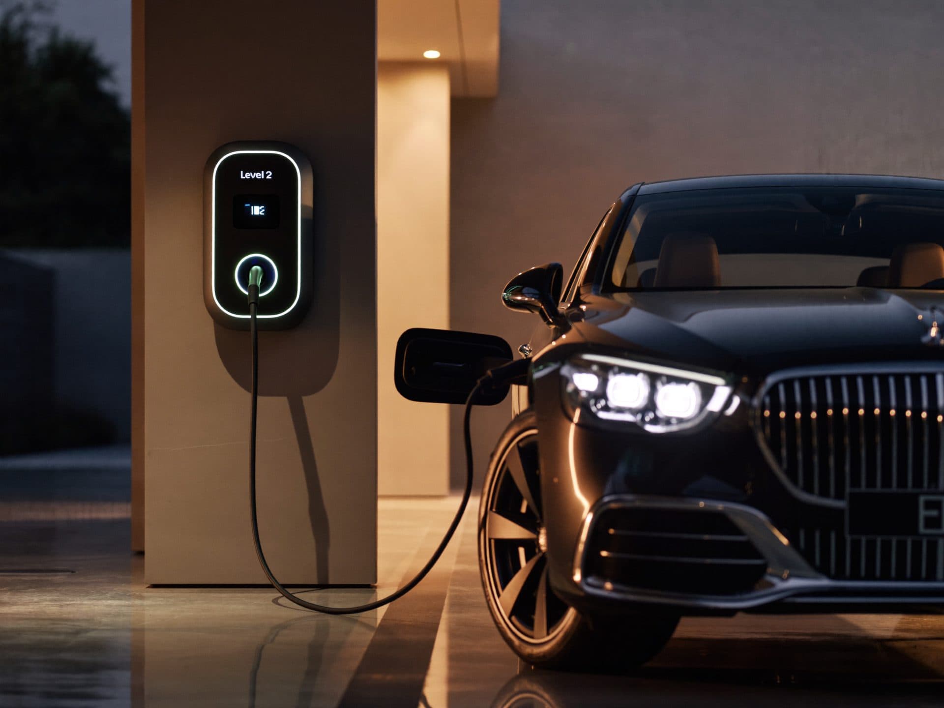 Luxury electric sedan charging from a wall-mounted Level 2 charger in a modern garage