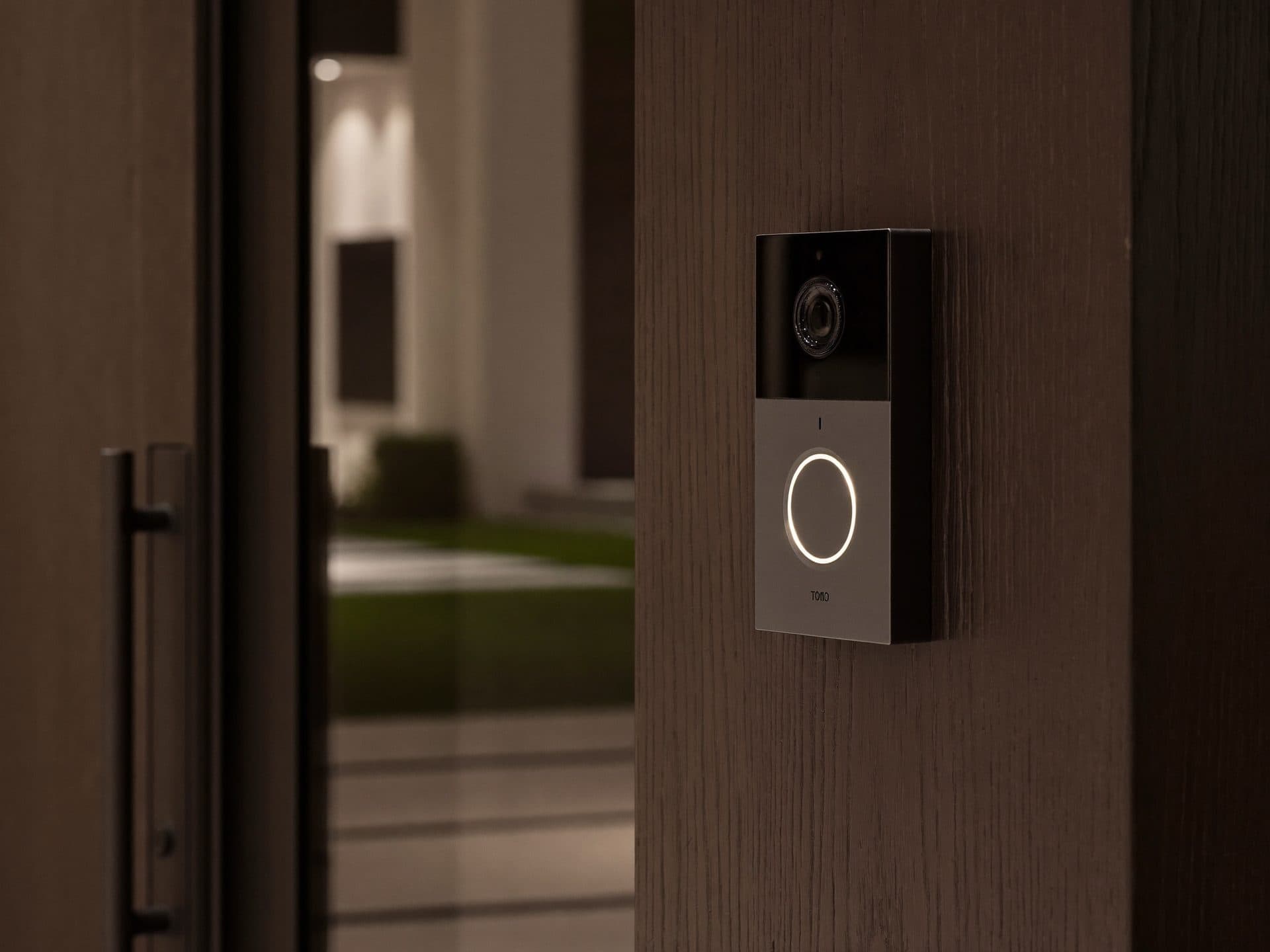 Video doorbell with a glowing ring on a modern home entry at dusk
